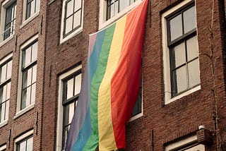 Pride flag hanging from a window