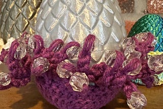 3D printed dragon eggs sitting in crocheted egg cups.