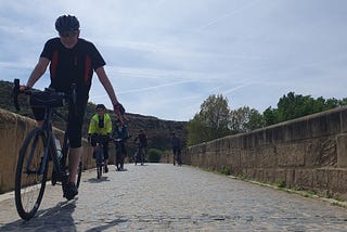 Riders on a bicycle crossing a bridge