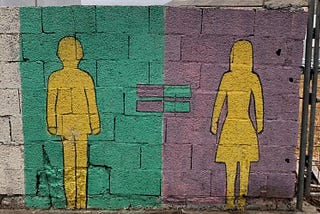 A graffiti on a wall showing a man silhouette and a woman silhouette with an equal sign inbetween.