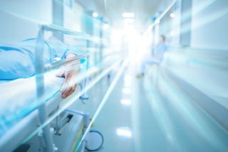 Dying patient in hospital corridor, with bright light in the distance