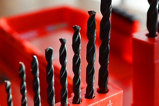 Eight drill bits sitting in a drill bit container