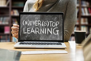 Picture of woman holding laptop that reads “never stop learning”