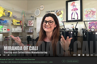 Miranda of Cali — Casting and Collectibles Manufacturing, image of owner in studio with supplies, machinery, and some of her illustrations on the wall.