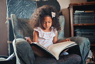 A little girl sitting with a book