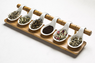A range of six different artisanal teas on a set of white spoons by Rujani Tea