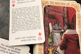 Tarot card with cats on it reads “Wheel of Fortune.” Motivation card says: “You can have whatever you want.” Another card says: “You deserve great things, so be willing to receive.”