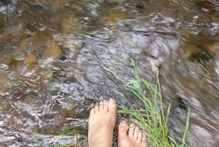 Naked feet in a cold rushing river
