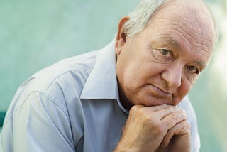 Seniors portrait of contemplative old caucasian man looking at camera. Image Credit: Diego Cervo/Shutterstock.