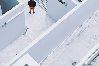 Aerial view of person in a maze-like building at the top of a staircase