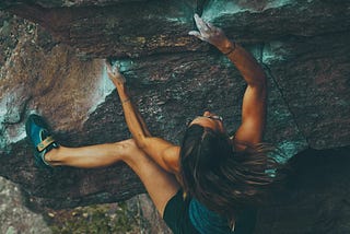 A woman scaling a rock face