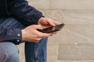 Man sitting on a bench using his mobile phone