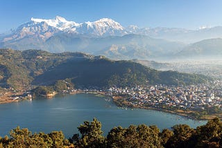 A Photo of a Annapurna mountain, Pokhara city and Phewa Lake taken from a high place.