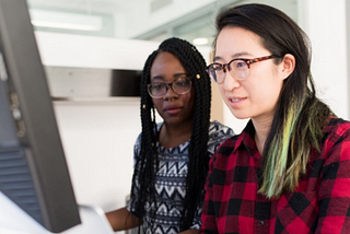 Two BIPOC women sitting at laptop.