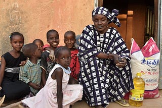 Ada et ses petits-enfants devant sa maison, après avoir acheté des vivres pour nourrir sa famille nombreuse. Photo : PAM/Mahamadou ABDOURHAMANE.