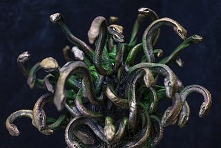 A bronze and green statue of snakes, remniscent of Medusa.