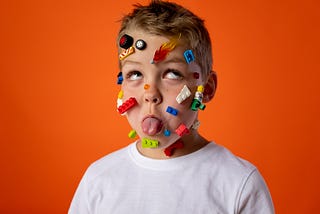 A boy sticking his tongue out with toys on his face