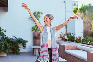 Woman Laughing while Raising Her Both Arms