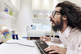 Man working at computer with hair blown back.