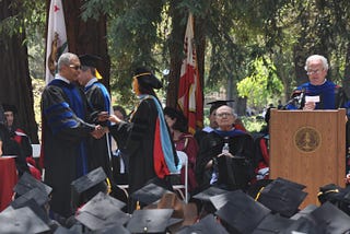 A student receives her degree during a graduation ceremony.