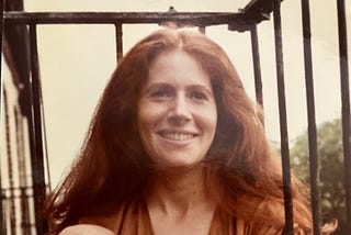 Woman with auburn-red hair smiles at camera