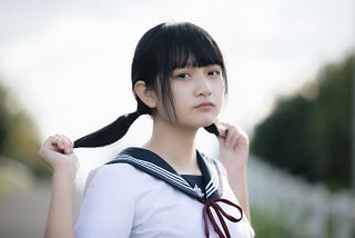 Japanese girl holding ponytails.