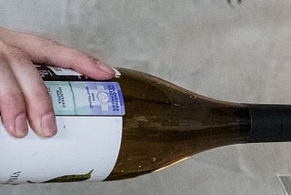 Person pouring wine out of a bottle