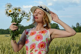 Dreamy woman with flowers in field.