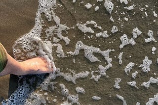 Feet in cool ocean water by Mark Tulin