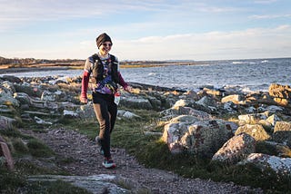 Woman runner running along the coast during a race