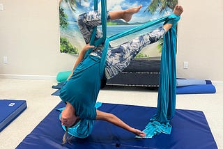 Woman hanging upside down on silks