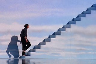 A still from the movie The Truman Show (1998) starring Jim Carrey walking up stairs that are painted like the sky.