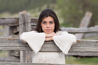 A woman gazing from the other side of the fence