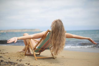 Woman relaxing on the beach in a deckchair