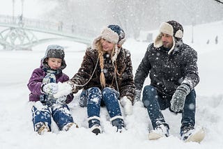 family sitting in the snow