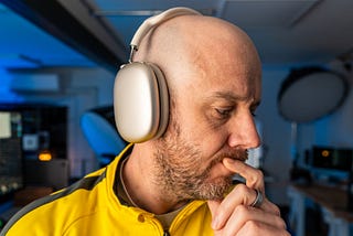 Side profile of Mark Ellis listening to his AirPods Max, seemingly contemplating the sound