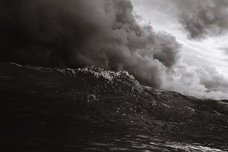 A wave cresting under a stormy sky