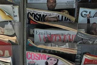 Rack of magazines at a newsstand including several Cosmopolitans