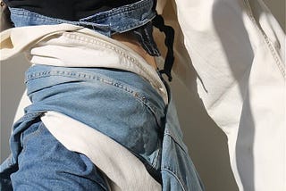 A close-up image of two people wearing mismatched denim in blue and white.