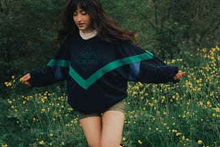 A photo of a girl walking in a field of flowers