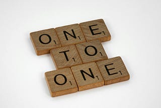 a photo of Scrabble tiles that spell “one to one”