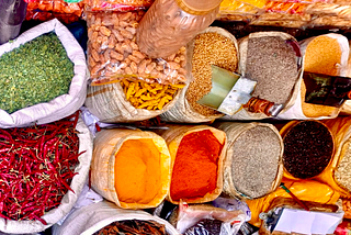 A variety of vibrant colour chillis, seeds and spices at a market.