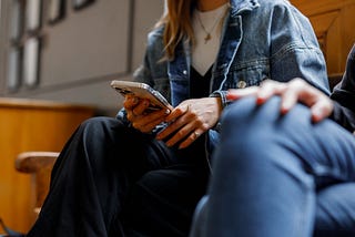 A student is holding a phone and talking to a friend