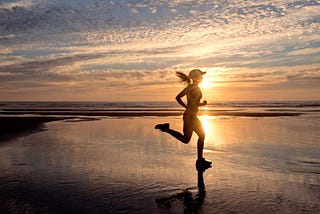 woman running on beach in the morning, runner’s high