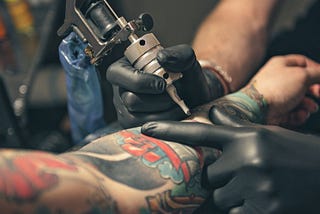 close up equipment for making tattoo art. Man doing picture on hand of woman