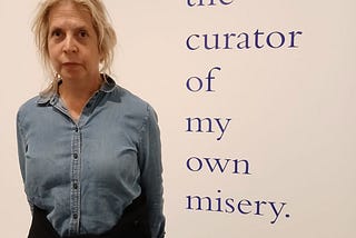 Picture of the author considering the statement, ‘I am the curator of my own misery,’ which was written on a wall of the Tate Modern Museum in London