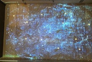 Picture of heavens depicted as a mixture of blue, white and violet hues with occasional stars as yellow dots