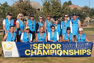 Beth and her 13 senior world championship team members in blue team jerseys wearing their gold medals