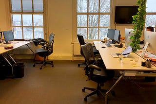 Four empty desks in an office building during winter