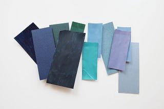 A group of painted samples including purple, blue, blue-green and green hues, in different saturations and lightness/darkness